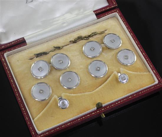 An early 20th century 9ct white gold, mother of pearl and diamond set eight piece dress stud set, in fitted box.